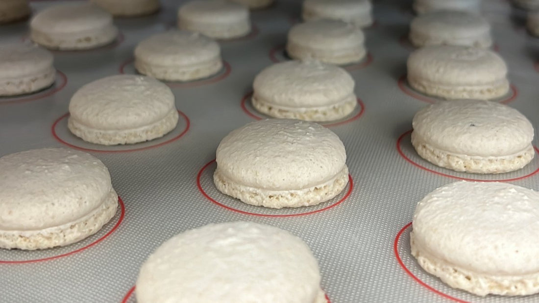 Gusci di macaron senza uova IN-VECE sul tappetino di silicone, con il piedino formato