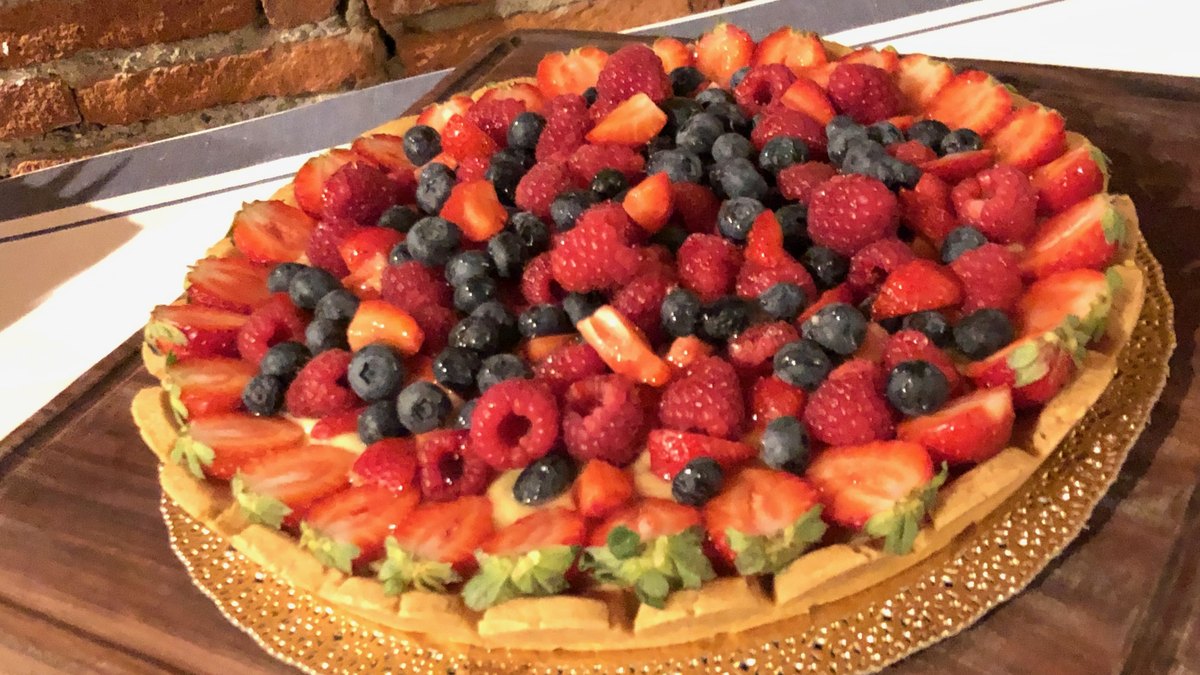 Crostata ai frutti di bosco con pasta frolla senza uova IN-VECE su tagliere di legno